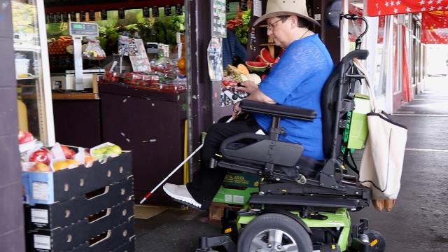 Woman in her electric wheelchair entering shop