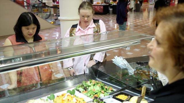 Two young Women being served at a counter